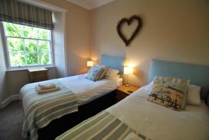 two beds in a room with a heart on the wall at Turnstone- beautiful coastal home Pittenweem in Pittenweem