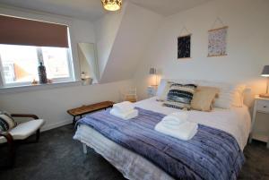 um quarto com uma cama com duas toalhas em Dookers Nook- Quirky coastal cottage Pittenweem em Pittenweem
