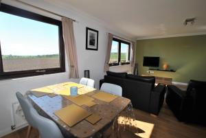 a living room with a table and a living room with a couch at Kellie View near Anstruther in Carnbee