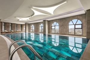a pool in a hotel with windows and a ceiling at Ramada by Wyndham Karapinar in Karapınar