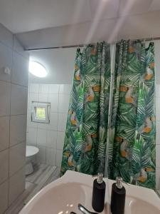 baño con lavabo y cortina de ducha en Koča Martuljek, en Gozd Martuljek