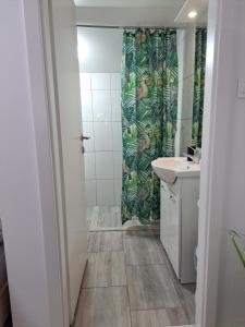 a bathroom with a shower curtain and a sink at Koča Martuljek in Gozd Martuljek