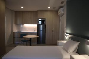a small room with a bed and a kitchen at MEU STUDIO in Gandra