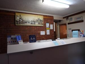 a cash counter in a room with a brick wall at Werribee Motel and Apartments in Werribee