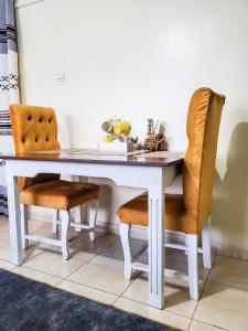 a white dining room table with two chairs at 1 BR, TreasureTree Homes, Thika in Thika