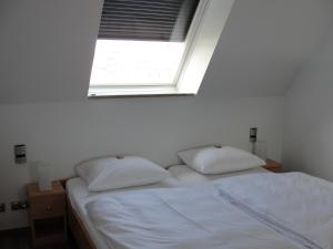 uma cama com duas almofadas num quarto com uma janela em Ferienwohnung Berliner Hof em Kiel