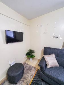 sala de estar con sofá y TV de pantalla plana en 1 BR, TreasureTree Homes, Thika, en Thika