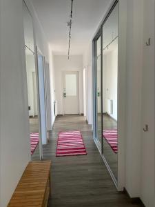 um corredor com espelhos e tapetes vermelhos no chão em Ferienwohnung Berliner Hof em Kiel