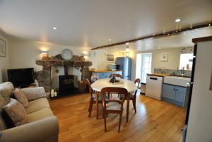 eine Küche und ein Wohnzimmer mit einem Tisch und einem Sofa in der Unterkunft Woods Neuk-stunning character cottage East Neuk in Pittenweem