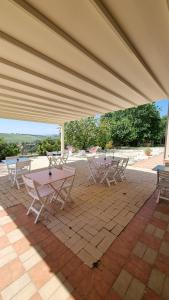 a group of tables and chairs under a large umbrella at B&B Ceresà - Country House in Loreto