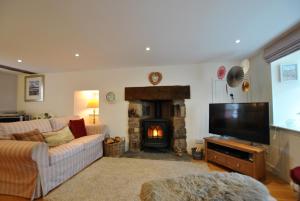 a living room with a couch and a fireplace at Woods Neuk-stunning character cottage East Neuk in Pittenweem