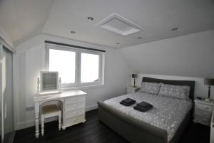 ein Schlafzimmer mit einem Bett und einem Schreibtisch mit einem Fernseher in der Unterkunft The Wendy House-seafront cottage incredible views in Anstruther