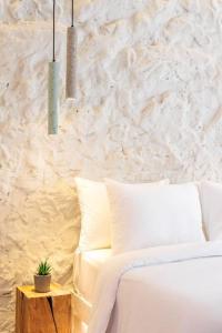 um quarto com uma cama branca e uma parede branca em Stylish & Tiny Room-City Center em Tessalônica
