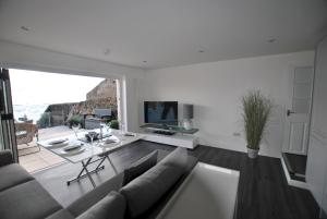 ein Wohnzimmer mit Sofa und Tisch in der Unterkunft The Wendy House-seafront cottage incredible views in Anstruther