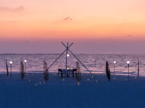 uma mesa na praia com o oceano ao fundo em Alila Kothaifaru Maldives 