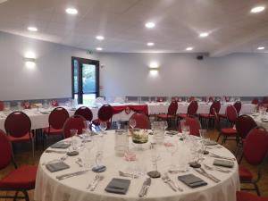 Habitación grande con mesas, sillas y cubiertos. en Au Relais de l'Oust, en Josselin