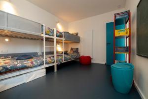 um quarto com 2 beliches e uma lata de lixo azul em Spacious family flat near the beach (6-8 pers) em Koksijde