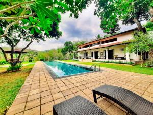 a swimming pool in front of a house at Leaf Watagala in Avissawella