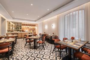 a restaurant with tables and chairs and a kitchen at Áurea Casa Palacio Sagasta by Eurostars Hotel Company in Cádiz