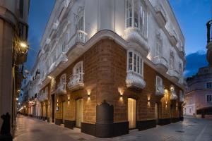 ein großes Backsteingebäude mit Fenstern auf einer Straße in der Unterkunft Áurea Casa Palacio Sagasta by Eurostars Hotel Company in Cádiz