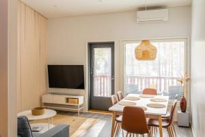 ein Wohnzimmer mit einem Tisch und einem TV in der Unterkunft Sun Villas A23 in Kalajoki