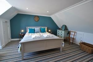 a bedroom with a large bed with blue walls at Shore Cottage Anstruther- stylish home by the sea in Anstruther