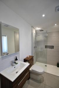 y baño con aseo, lavabo y ducha. en Shore Cottage Anstruther- stylish home by the sea, en Anstruther