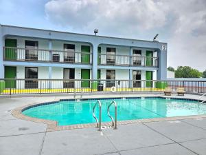 a hotel with a swimming pool in front of a building at SureStay Studio by Best Western Victoria in Victoria