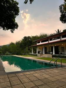 ein Swimmingpool vor einem Haus in der Unterkunft Leaf Watagala in Avissawella