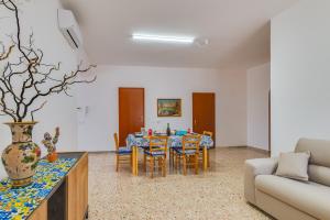 sala de estar con mesa, sillas y sofá en Matisé Home Relax en Sciacca