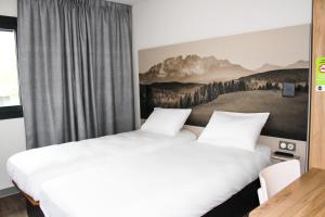 sypialnia z 2 łóżkami i obrazem na ścianie w obiekcie B&B HOTEL Aix-les-Bains w mieście Grésy-sur-Aix +36 zdjęć