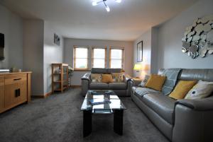 a living room with couches and a coffee table at Jessies Selkie- homely apartment in East Neuk in Anstruther