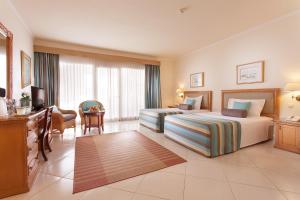 Golf Beach Resort - Ultra All Inclusive في شرم الشيخ: غرفة فندقية بسريرين ومكتب