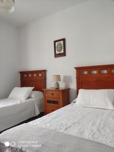 a bedroom with two beds and a clock on the wall at VILLA LOS GALLOS in Chiclana de la Frontera