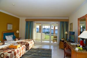 Golf Beach Resort - Ultra All Inclusive في شرم الشيخ: غرفة فندقية بسريرين ومكتب