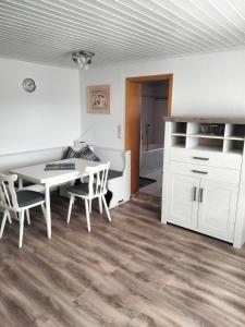 a room with a table and chairs and a kitchen at Ferienwohnung Odorfer in Pleinfeld