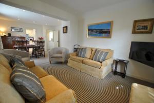 a living room with a couch and a tv at Dolphin Cottage- traditional cottage on Fife Coast in Anstruther