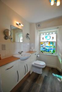 a bathroom with a sink and a toilet and a window at Dolphin Cottage- traditional cottage on Fife Coast in Anstruther