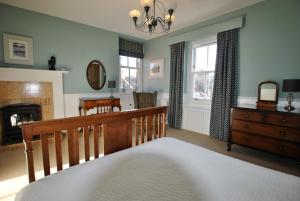 1 dormitorio con cama, escritorio y chimenea en Willow Cottage- charming cottage in East Neuk en Pittenweem