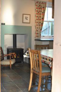 Una sala de estar con una mesa y una chimenea. en Willow Cottage- charming cottage in East Neuk, en Pittenweem