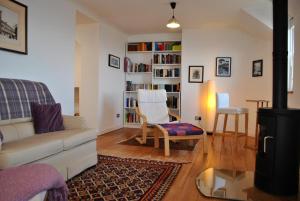 a living room with a couch and a book shelf at The Loft- charming character cottage in East Neuk in Anstruther