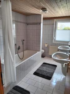 a bathroom with two sinks and a tub and a shower at Ferienwohnung Odorfer in Pleinfeld