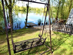 a swing in a yard with a view of a lake at The Hideaway Pod in Chelmsford