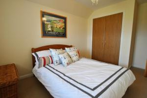 a bedroom with a bed with white sheets and pillows at Seaview Steading-spacious home in rural location in Crail