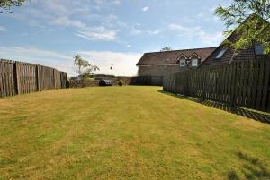 a yard with a fence and a house at Seaview Steading-spacious home in rural location in Crail