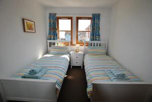 two twin beds in a room with a window at Seahaven- family home in East Neuk coastal village in Anstruther