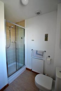 a bathroom with a toilet and a glass shower at Seahaven- family home in East Neuk coastal village in Anstruther