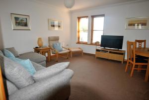 a living room with a couch and a television at Seahaven- family home in East Neuk coastal village in Anstruther