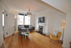 a living room with a couch and a fireplace at Creel Cottage- stylish cottage near the sea in Anstruther