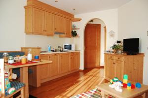 cocina con armarios de madera y cocina con mesa en Hotel Lido - green & slow life en Molveno